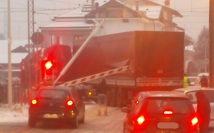 Camion incastrato nei binari tra le sbarre del passaggio a livello